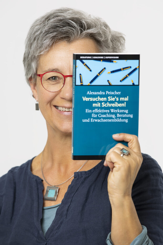 Alexandra Peischer hält ihr Buch "Versuchen Sie's mal mit Schreiben!" in die Höhe