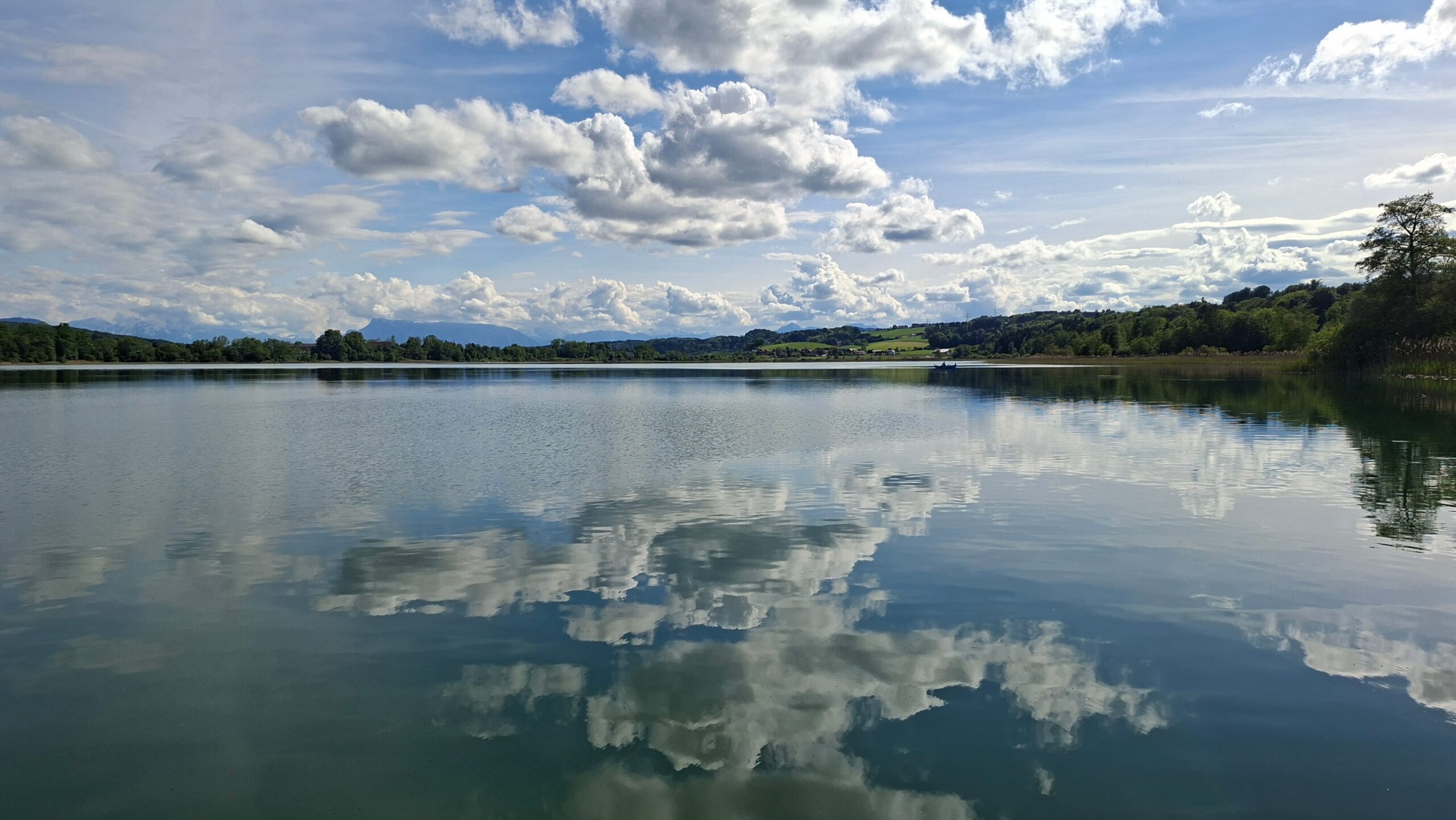 Wolken spiegeln sich im See